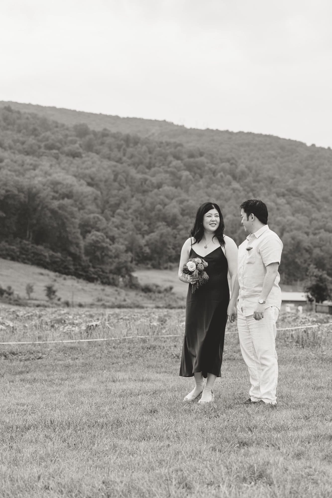 Jeffrey and Katie standing together in a meadow below the hills